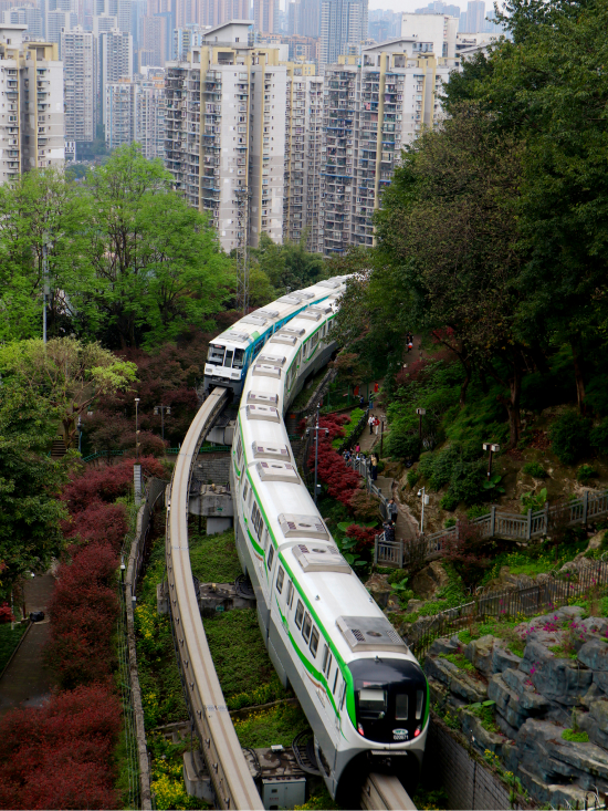 Light rail trains weaving through Chongqing's forested areas with skyscrapers in background